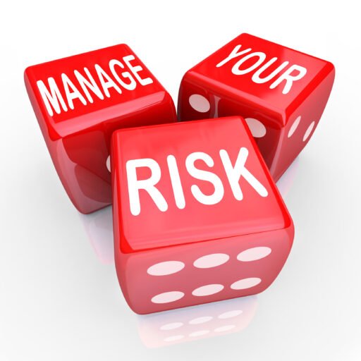 Three red dice with white dots, two showing words ‘MANAGE’ and ‘YOUR’ and one showing the word ‘RISK,’ illustrating risk management.